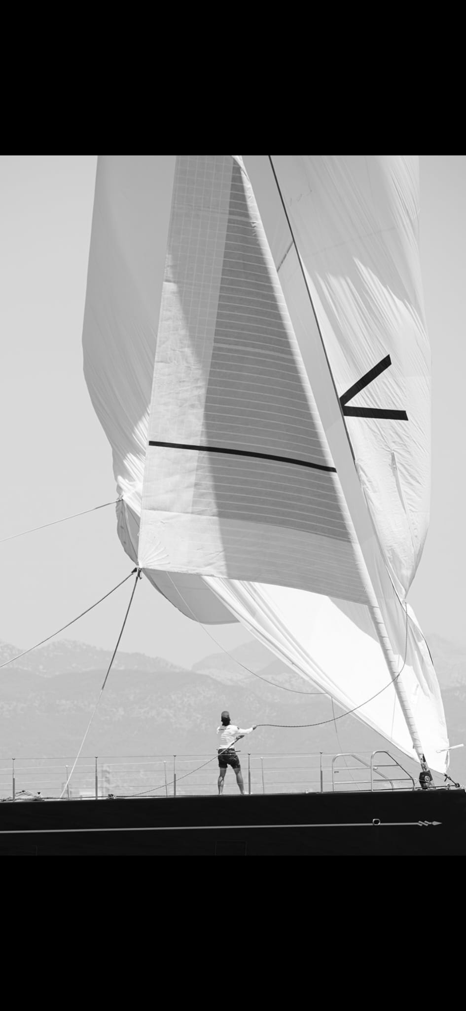 A sailor handling the headsail on a sailing yacht
